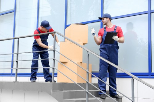 Workers wearing PPE while loading items into a van for a Coulsdon move